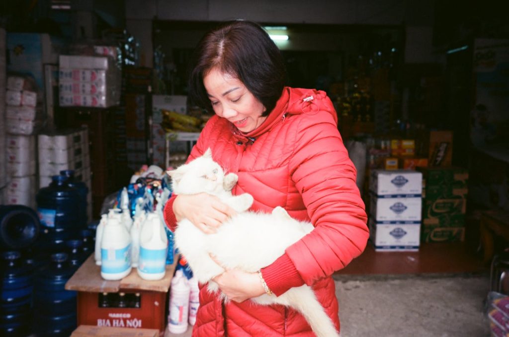 Woman in Red Coat Holding White Cat