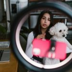 Young woman vlogging with her dog at home, creating content indoors.